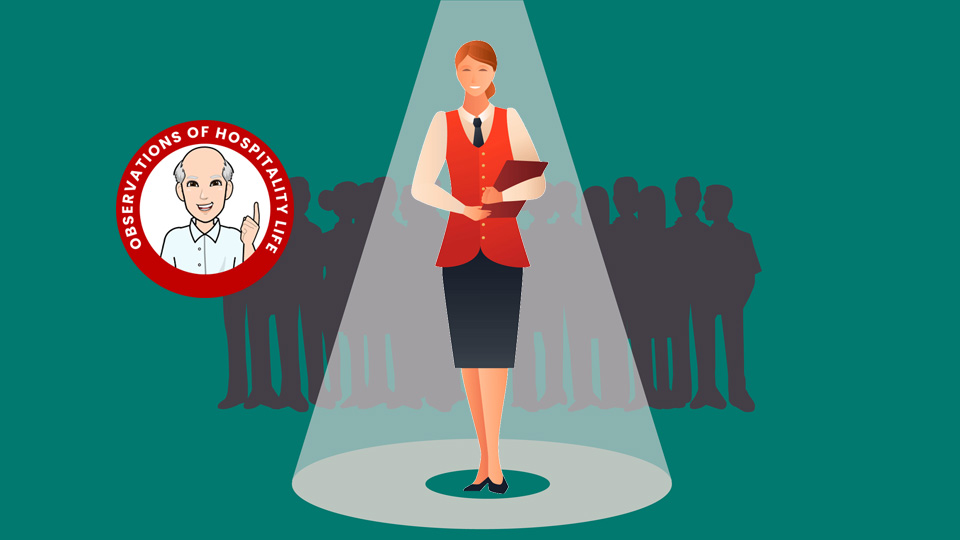 Hotelier standing in a spotlight with a green background and other hoteliers behind her. Article 4 qualities of a standout teammate by MY RANGGO Hospitality Magazine