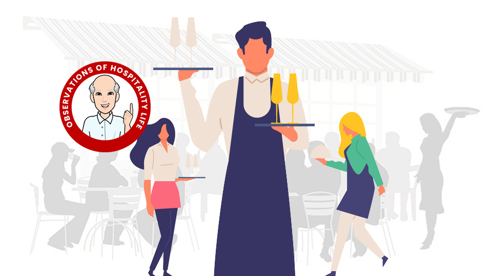 Waiter standing in a busy restaurant, holding a tray with food and drink. Article How To Be A Good Waiter by MY RANGGO Hospitality Magazine