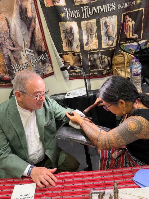 A Photo of Teodoro Locsin III, getting a traditional, handtapped Batek Tattoo from Ate Wamz, at a Tattoo Convention in London, UK